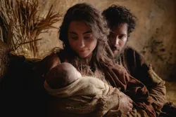 Joseph and Mary hold the newborn baby Jesus Christ in their arms