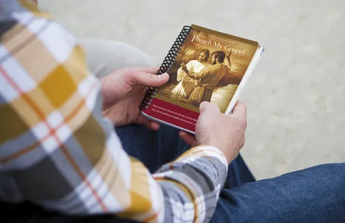 young man holding Preach My Gospel