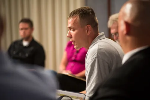 Men and women meeting together in an addiction recovery program.