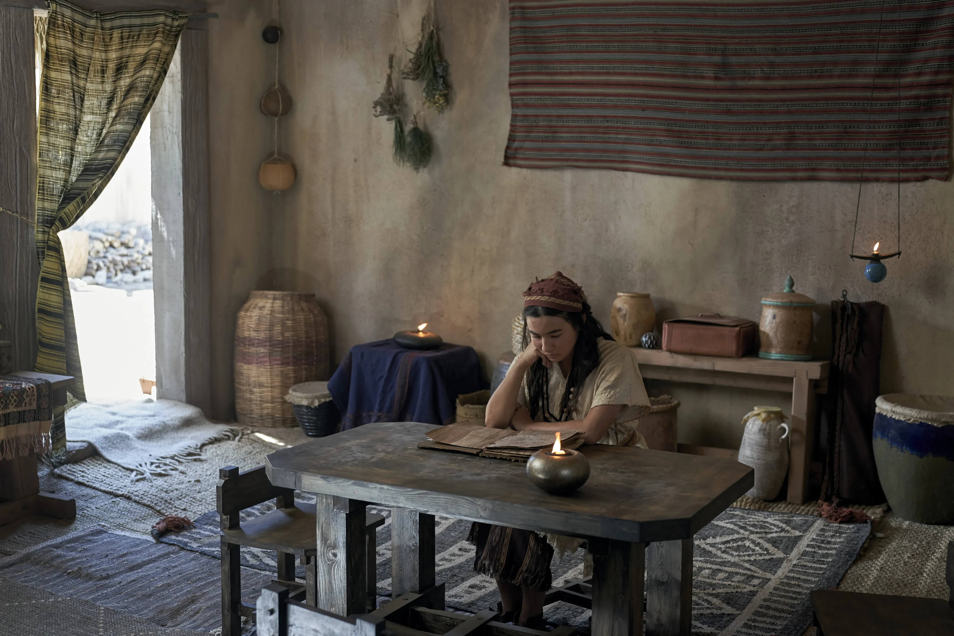 The wife of Enos reads in her home.