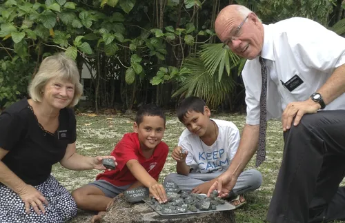 senior missionary couple and children showing rocks