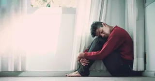 a young adult sits curled up