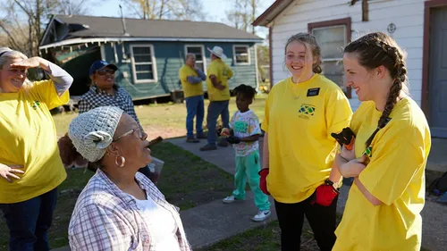 missionaries talking with a woman while providing service