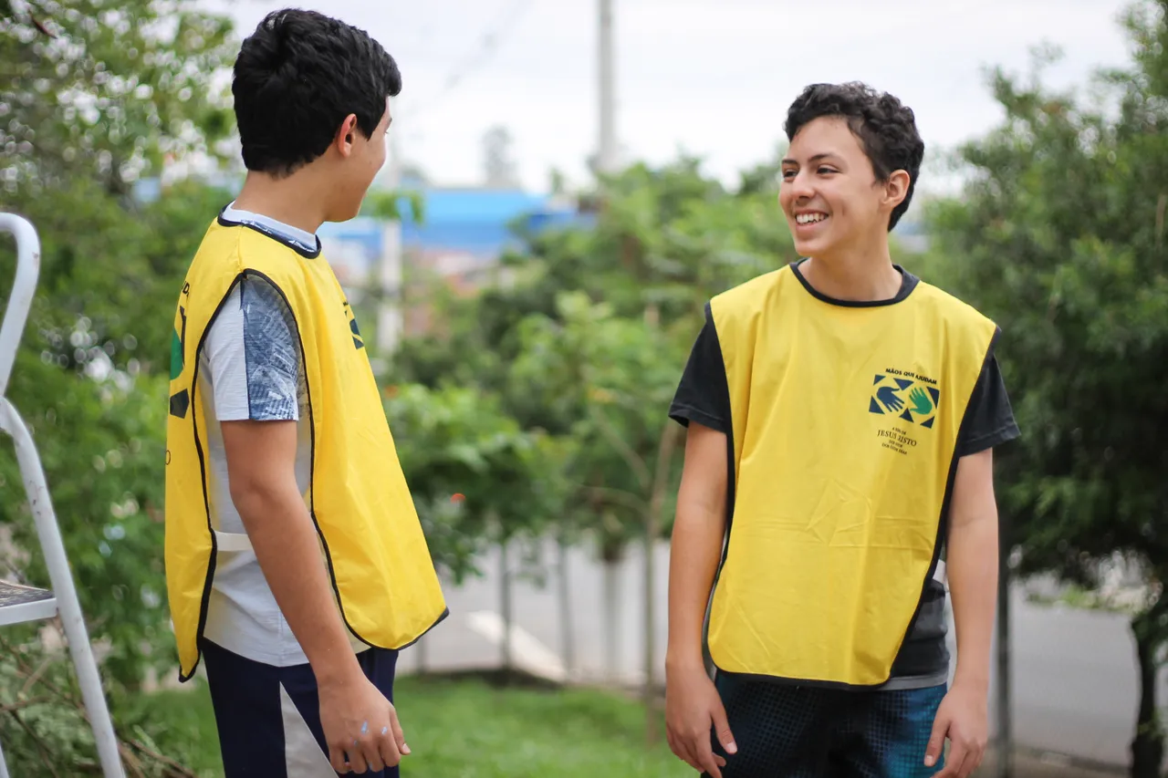Two young men wearing helping hands shirts preform service after a natural disaster