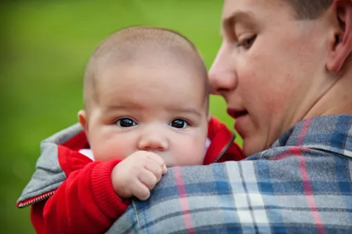 Older brother holding baby