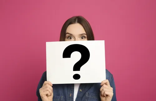 woman holding a sign with a question mark