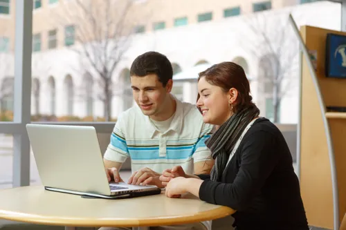 A woman and a man using a laptop computer