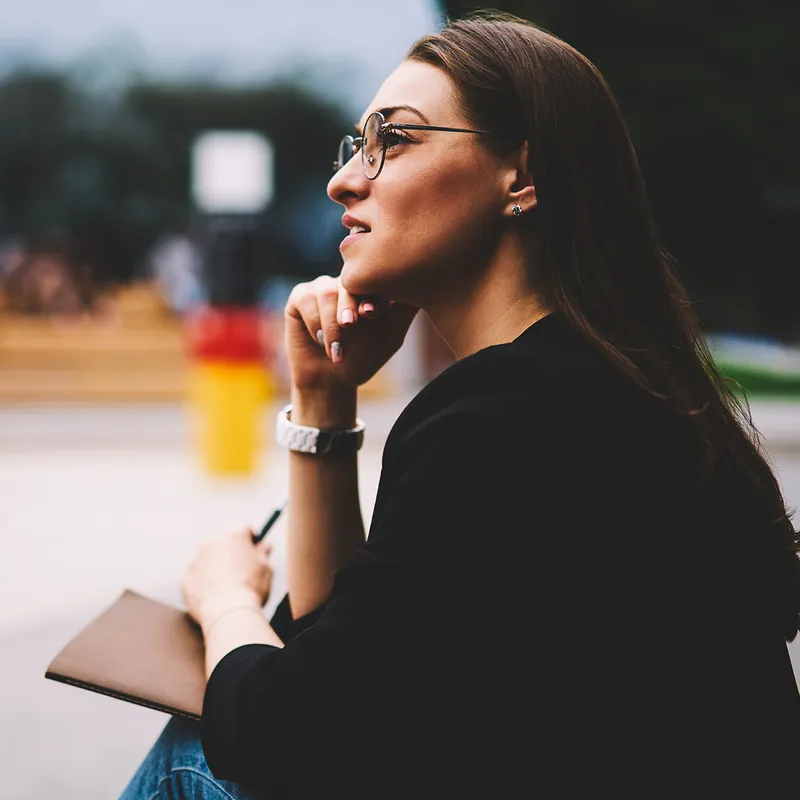 A woman sits on a park bench contemplating the purpose of life