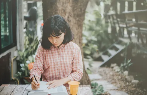 young woman studying scriptures outside