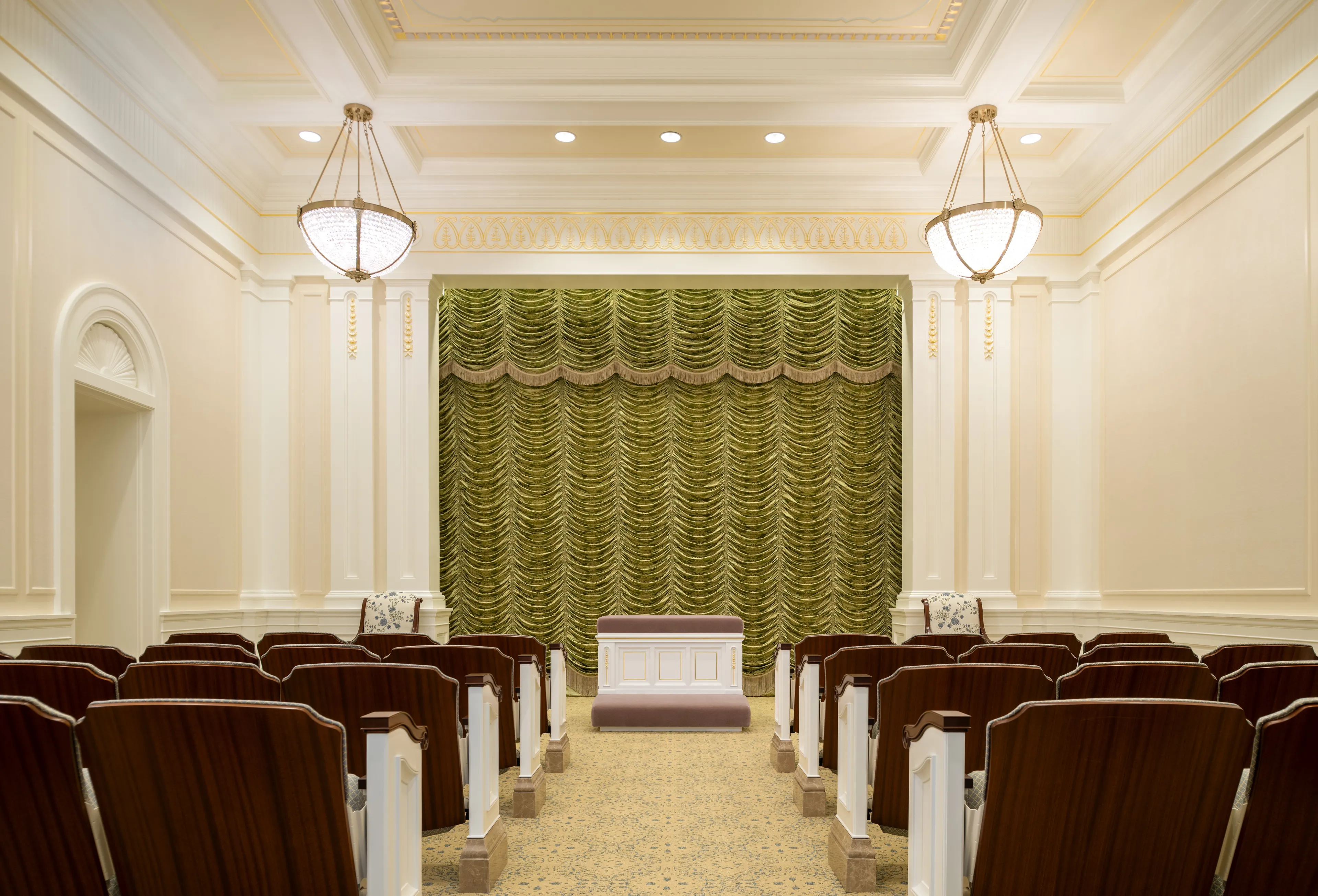 Interior image of the Deseret Peak Utah Temple. The image highlights the seats in the room and an altar in the front.