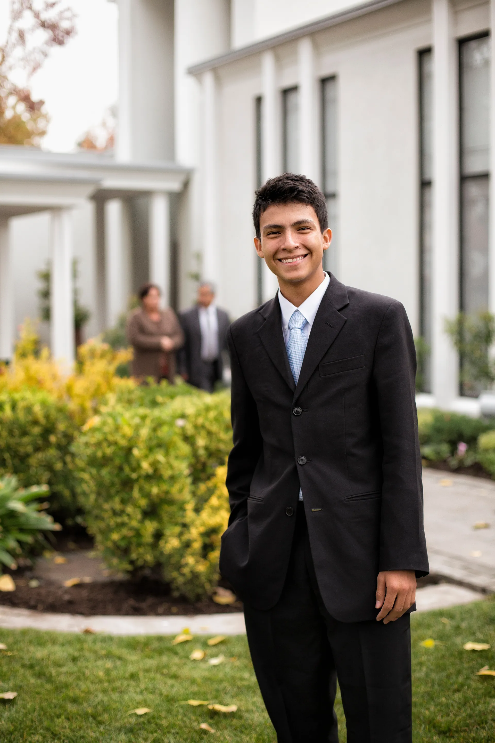 A young man in a suit standing outside the Santiago Chile Temple.