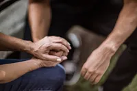 A hand is held in the hand of another