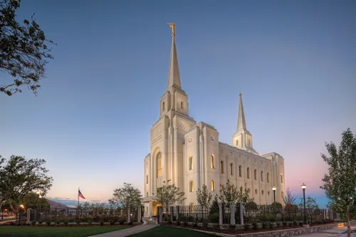A side view of the Brigham City Utah Temple in the evening, with lights illuminating the temple from within and without.
