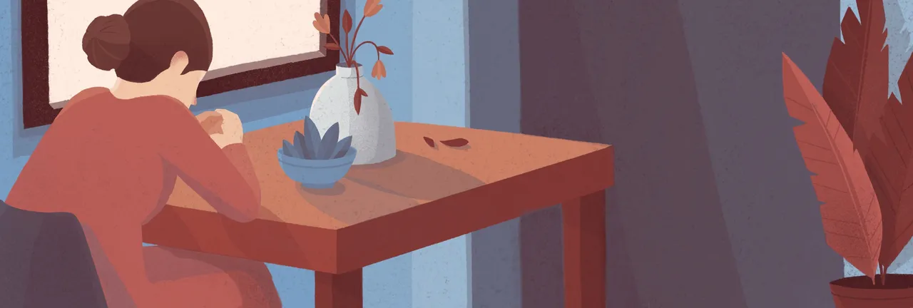 A woman sits at her table and prays