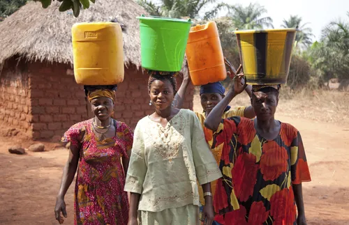Women walking with containers on heads