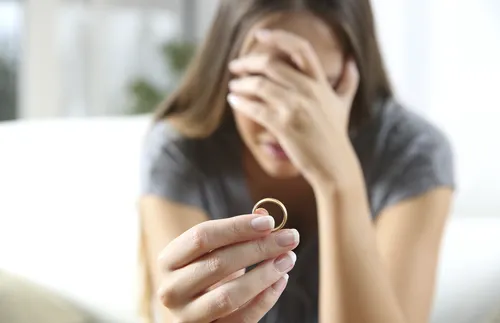 distraught young woman holding a ring