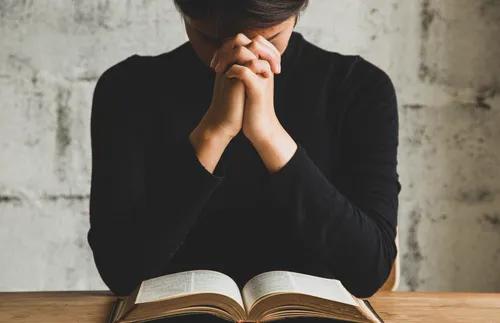 person sitting at table praying