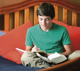young man writing in journal