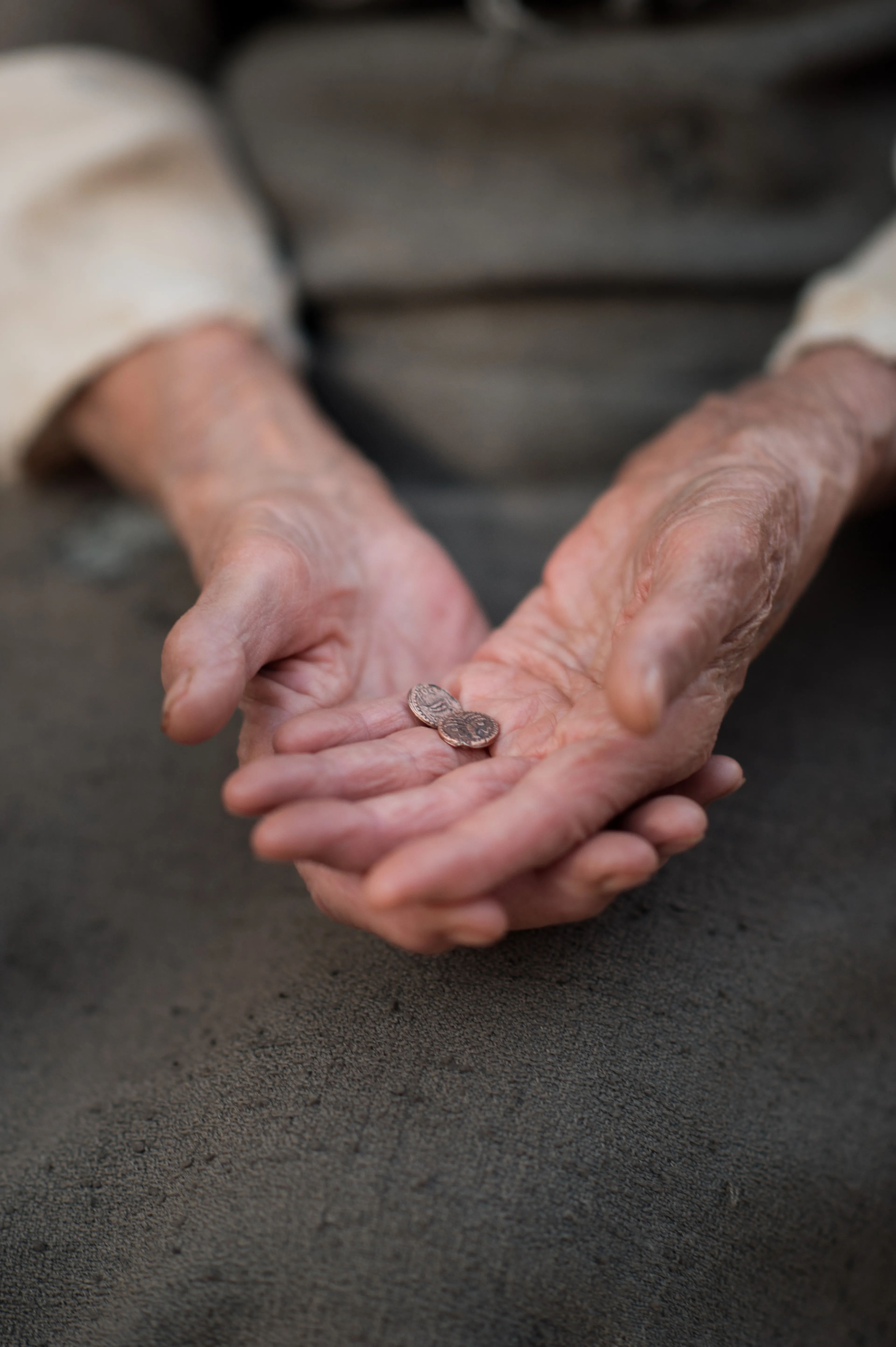 A widow holding two mites in the palm of her hand.
