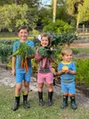three children holding up fresh vegetables