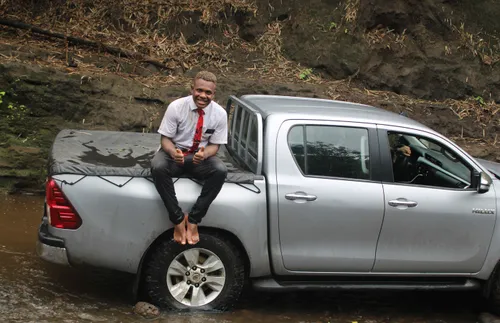 missionary sitting on bed of truck