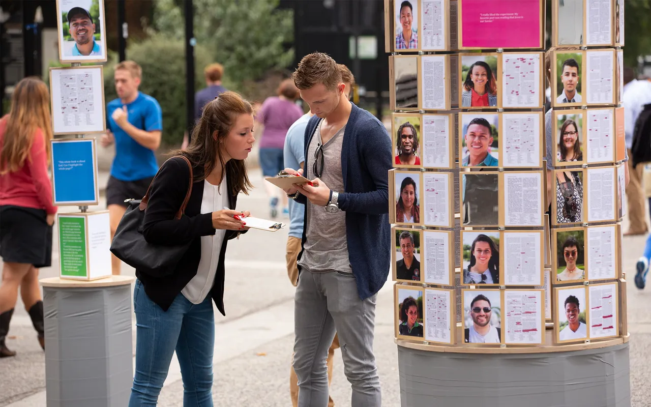 A man and woman mark Book of Mormon passages on clip boards learning about Jesus Christ