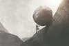 man pushing a rock up a hill