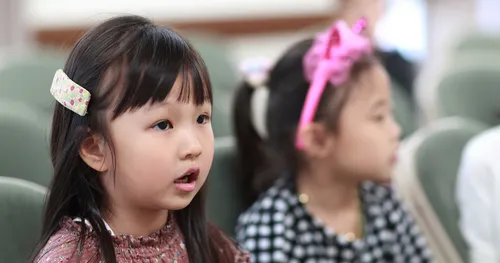 Primary-age girls watch activity.