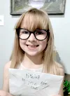 Smiling girl holding tithing envelope