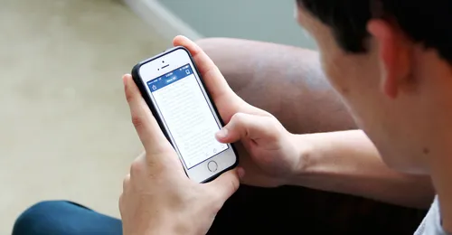 Young man reading scriptures on phone