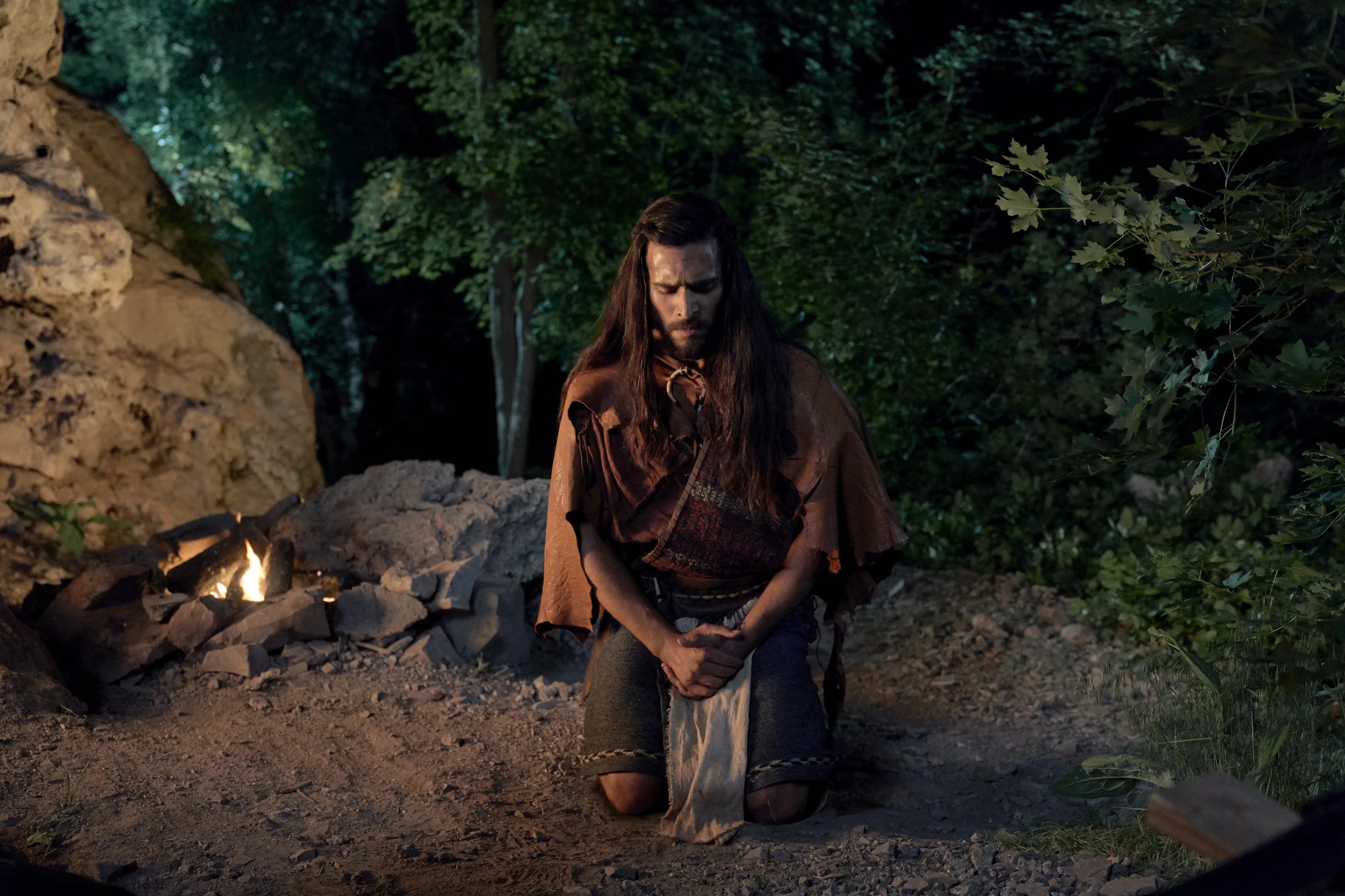 Enos prays in the forest at night.