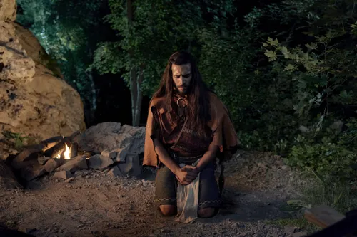 Enos prays in the forest at night.