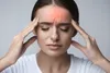 woman in pain touching her head