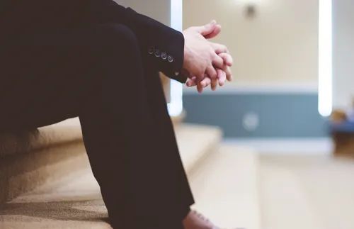 man sitting with arms resting on knees