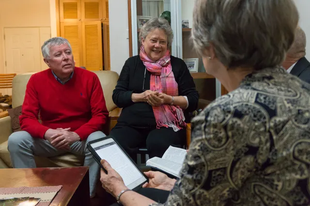 Meeting with senior missionaries.  Sister missionary is holding tablet computer while her husband is holding open scriptures. (horiz)