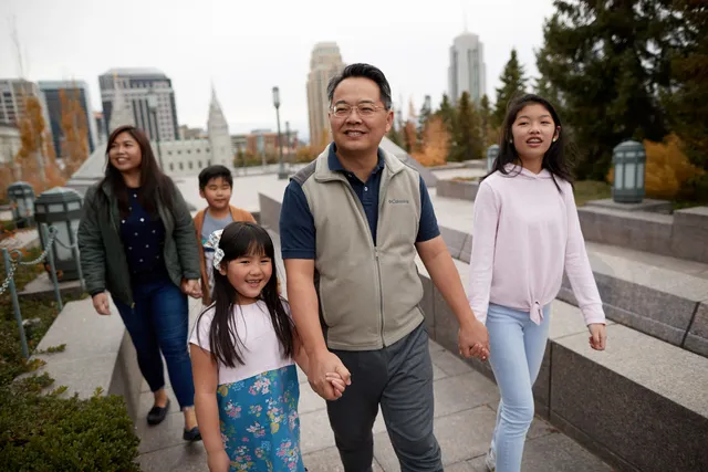 A family is together on the roof of the Conference Center. They are smiling and talking to one another.