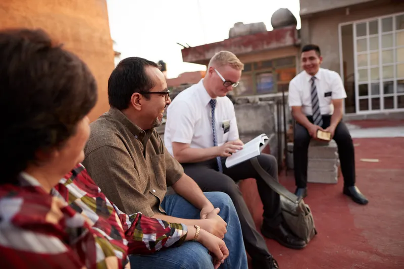 Missionaries teaching married couple about eternal families on a rooftop