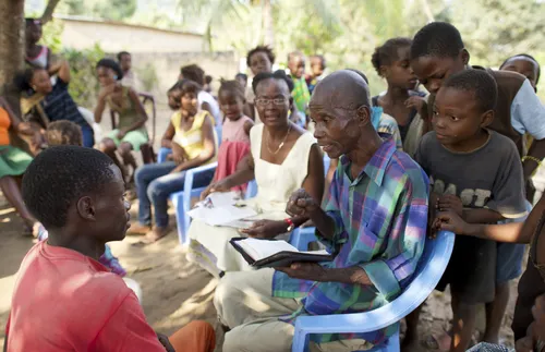 man teaching boy with others gathered around