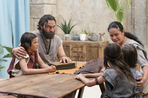 King Benjamin gathers with his family around a table in the Land of Zarahemla and tells them he can no longer be king. He shows his family the brass plates.