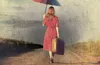 woman walking with umbrella and suitcase