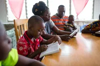 A father studies the Bible with his children