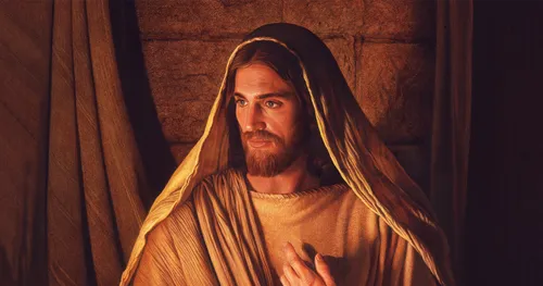 face of Jesus lit by candles in dark room