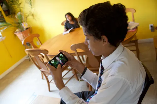 young man watching general conference on a phone
