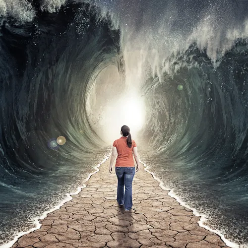 young woman walking on dry ground through parted sea