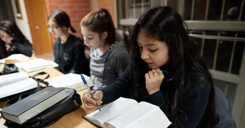young men and young women studying in seminary class