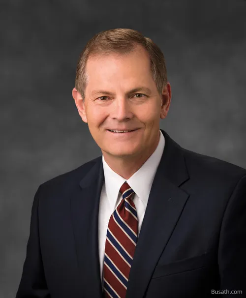 Retrato del élder Gary E. Stevenson que lleva puesto un traje oscuro y una corbata a rayas en un fondo gris.