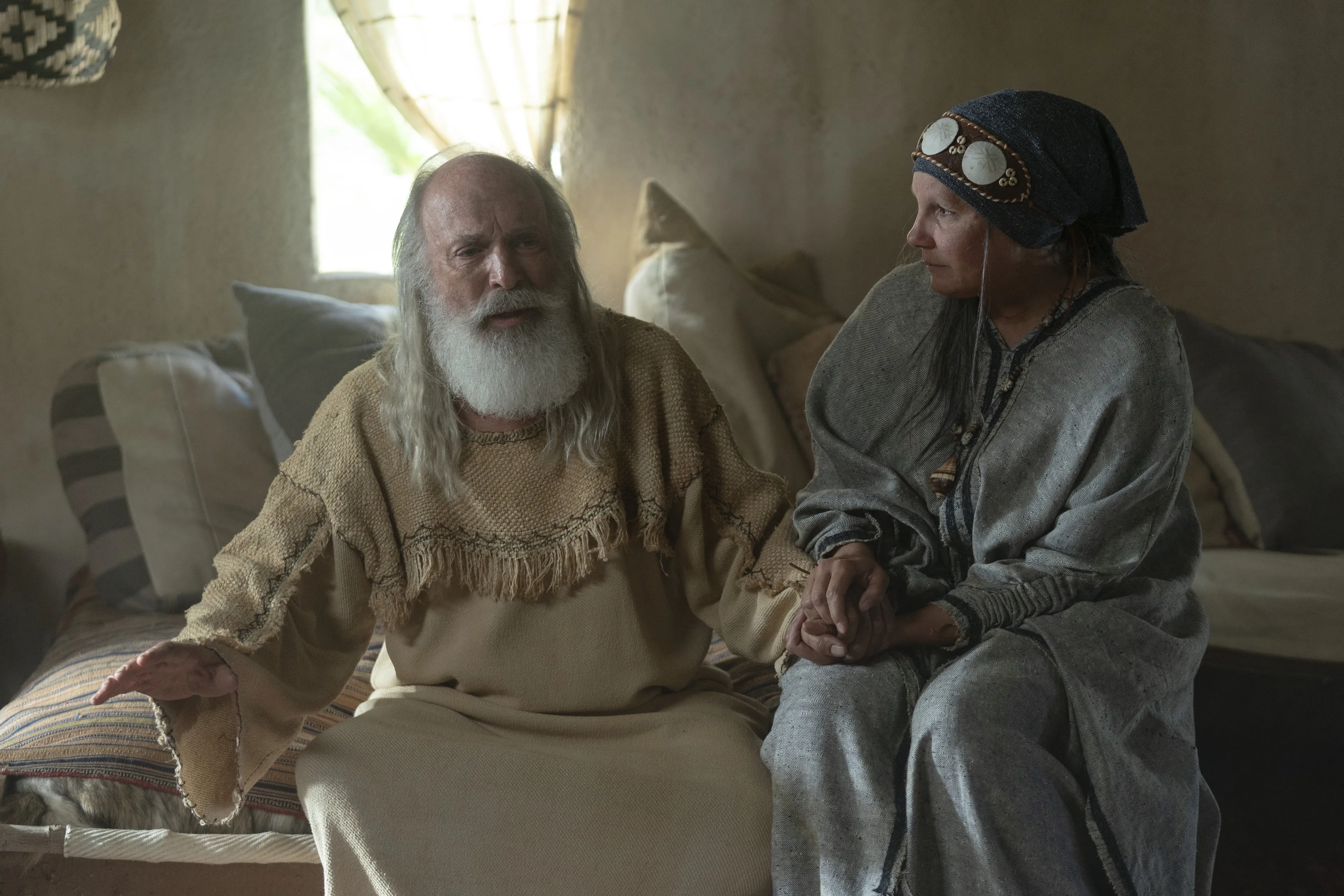 Sariah sits by Lehi as he teaches their family.