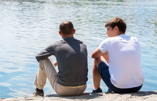 two friends talking by a river