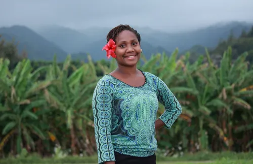 young woman with flower in her hair standing outside