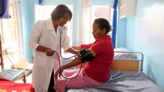 A doctor meets with her patients and checks blood pressure.